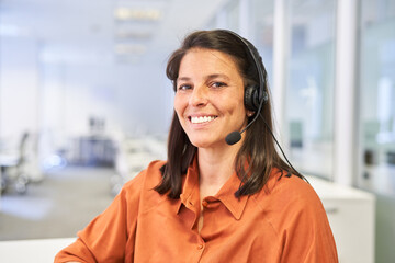 Smiling business woman with headset in call center