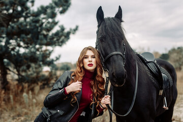 Obraz premium Beautiful young woman posing with a horse outdoors, close up