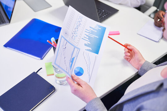 Business man holding paper with charts for financial analysis