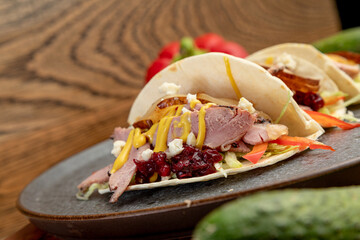 smoked meat tacos served on a black plate.
