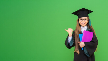 A schoolgirl with textbooks on a green isolated background. copy space.