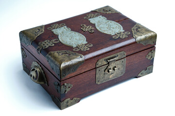 Old wooden box with patinated brass elements on a light background. Close-up. Selective focus
