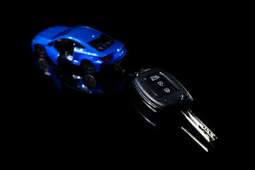 buy new car, rental or leasing - automobile model with remote key on black background
