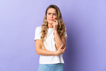 Young Brazilian woman isolated on purple background having doubts and thinking