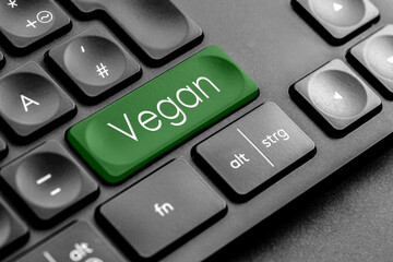 dunkelgrüne "Vegan" Taste auf einer dunklen Tastatur