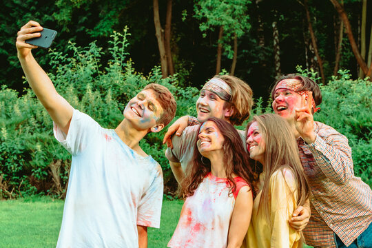 friends at holi fest taking selfie on the phone
