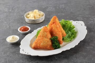 Triangle Fried Risoles or Risol is Indonesian Traditional Street Food made from Flour Skin with Potato, Cheese,  and Vegetables Inside.