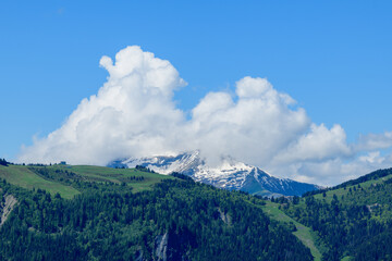 Obraz premium Clouds over Mont Joly and Col de Voza in the Mont Blanc Massif in Europe, France, the Alps, towards Chamonix, in summer, on a sunny day.