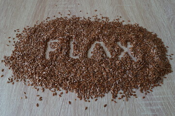 Organic flax seed on a wooden background. Flaxseed is very useful in the diet, lowers cholesterol and prevents heart disease.