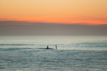 Jet ski towing a foil surfer during the sunset on atlantic ocean