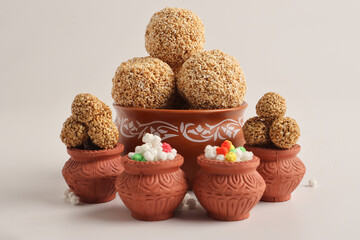 Til Gul OR Sweet Sesame seed ball or Laddu with Fikri for Indian festival Makar Sankranti over white background.