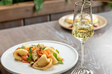 a glass of champagne served with pancakes with salmon. photo of the dish in the interior