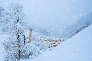 Snowflakes falling on mountain huts in the fairy tale alpine village at Christmas time, Valgerola, Valtellina, Lombardy, Italy