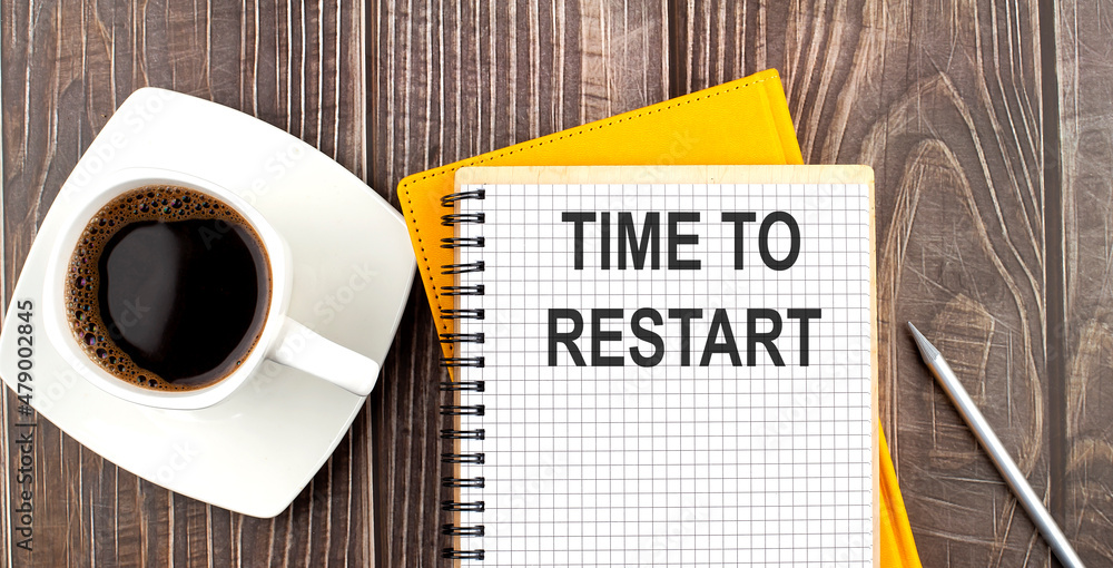 Aufkleber time to restart text on the notebook with coffee on wooden background