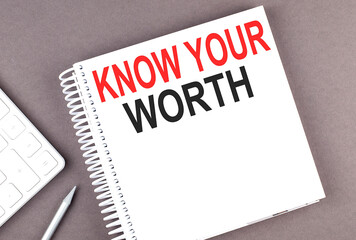 KNOW YOUR WORTH text on the notebook with calculator and pen