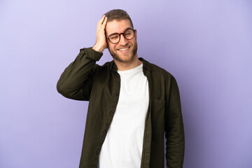 Young handsome caucasian man isolated on purple background smiling a lot