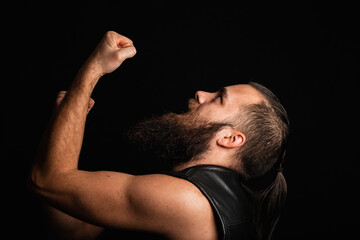 Portrait of a handsome, bearded biker, pumping fist in success