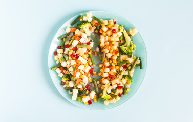 The concept of using quick-frozen products. A mixture of frozen vegetables and warmed vegetables in one plate