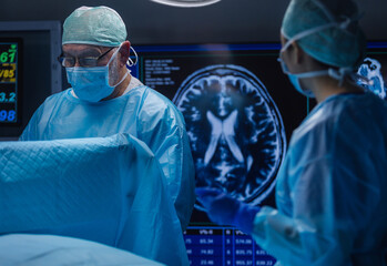 Multiracial team of professional medical surgeons performs the surgical operation in a modern...