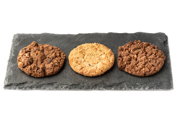 Oatmeal muesli cookies of different varieties on a stone board for serving.