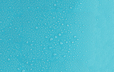 Light blue background with large and small drops of water in natural light. The texture of a water drop on a colored background is a top view.