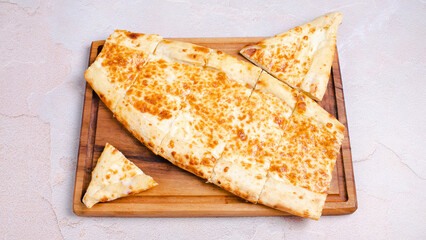 Turkish cheese pide sliced on wooden tray