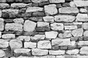 Black and white stone wall for background design. Vintage of stone backdrop. Natural stone wall textured background for a poster, calendar, screensaver, wallpaper, postcard, banner, cover, website
