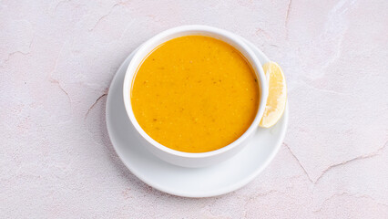 Turkish lentil soup with lemon slice isolated on white.