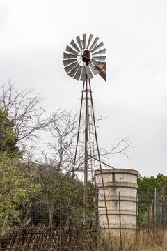 A view of an old western wind powered water well and tank, historic Philip Bauer House, circa 1878, Guadalupe State Park, Texas