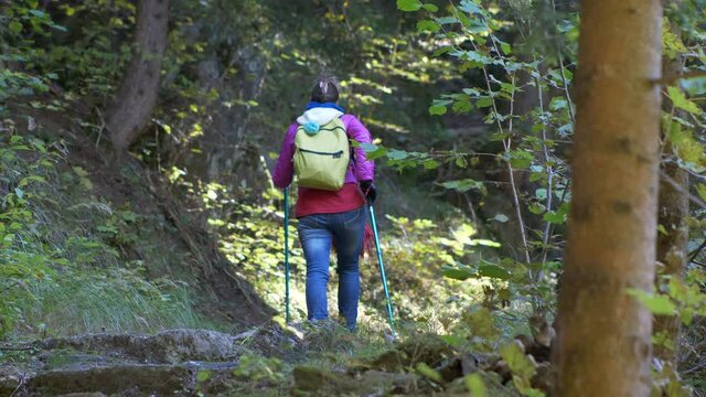 Woman with backpack climbs the mountain path. Climb impervious. Slow motion 4K