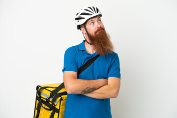 Young reddish caucasian man with thermal backpack isolate don white background and looking up