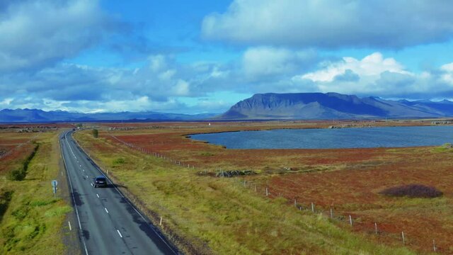 panoramic aerial landscape of car driving on road close to pond