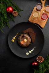 aspic served with black bread on a dark plate with mustard and horseradish on a dark Christmas...