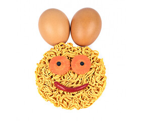 Instant noodles or dry noodles circle with carrots,red chili,two eggs and black pepper smiling isolated on white background top view.