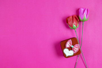 Pink background top view for Valentine's day with Red gift box ,Plastic pink roses and red roses.