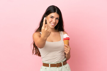 Young caucasian woman with a cornet ice cream isolated on pink background doing coming gesture