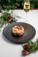 Olivier salad with salmon, on a white Christmas background. traditional Russian poisoning for New Year and Christmas.