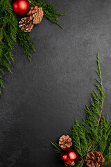 new year or christmas dark background decorated with toys, pine cones and fir branches