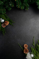 new year or christmas dark background decorated with toys, pine cones and fir branches