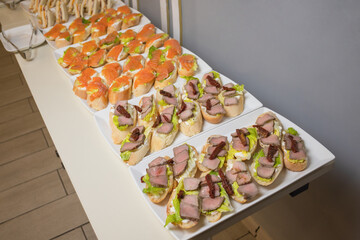Plate of many mini bite size sandwich appetizers.