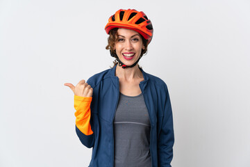 Young cyclist woman isolated on white background pointing to the side to present a product