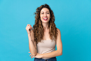 Young caucasian woman isolated on blue background laughing