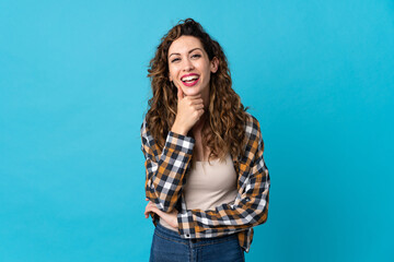 Young caucasian woman isolated on blue background happy and smiling