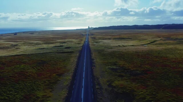 Aerial vertical panoramic view of road, field, ocean and mountain range