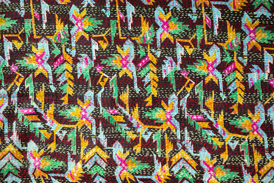 Close-up of kantha stitch recycled vintage silk fabric. Needlework technic of textile decoration, DIY kantha quilt. Handmade stitch on colourful retro fabric with geometric pattern. Ethnic, boho style