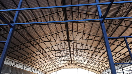 Steel columns and building roof structures. Details of the roof of an industrial building covered with metal sheet in the view below. selective focus