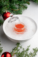 red caviar on a white Christmas background decorated with toys and branches