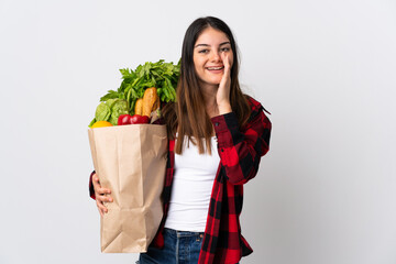 Young caucasian with vegetables isolated on white background shouting with mouth wide open