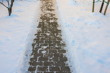 Beautiful view of path from paving slabs in winter garden leading to house. Sweden.