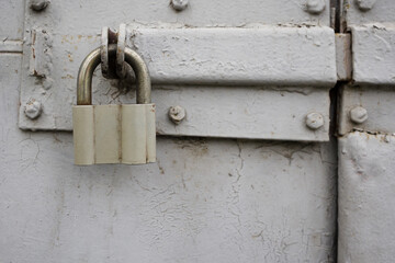 Old padlock on metal gate close up view